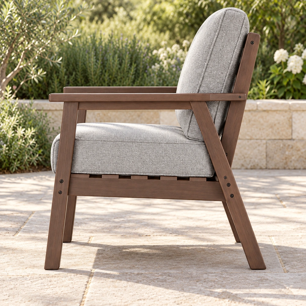 True side view of brown cushioned HDPE outdoor lounge armchair on a limestone garden patio