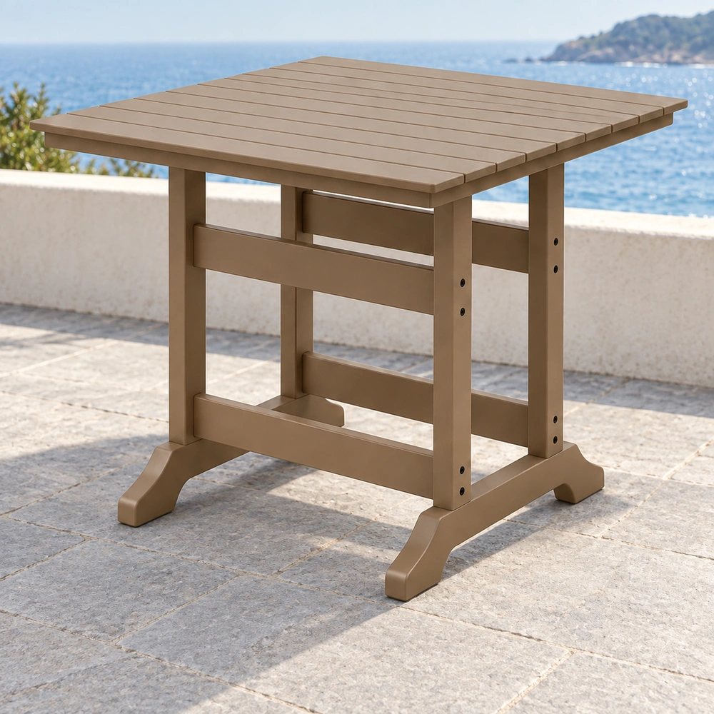 Rear-right view of the taupe square trestle-base HDPE dining table on a pale-stone coastal terrace